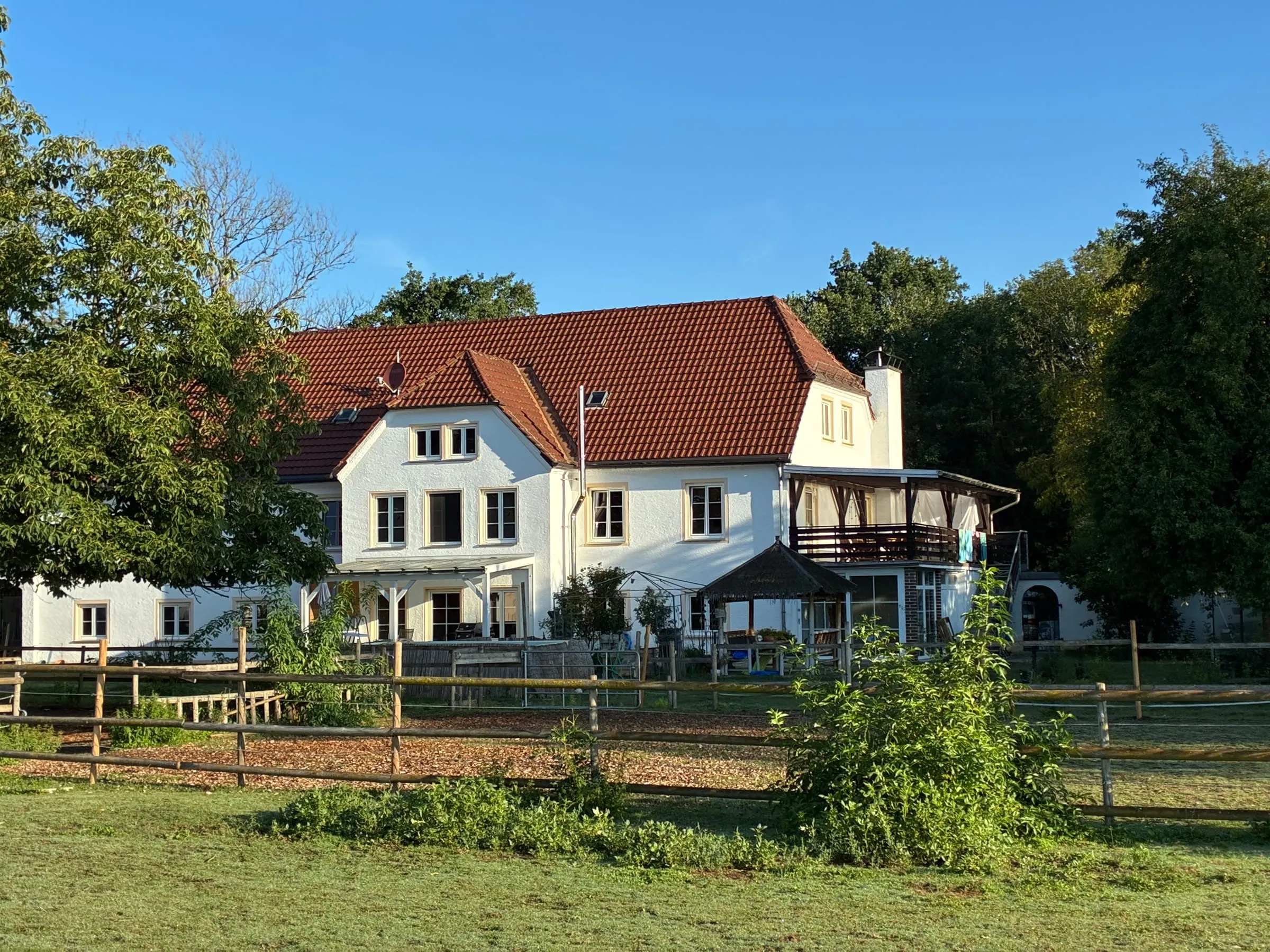 Das Haus auf dem Hof in Dorfreit im Chiemgau, davor Koppel und Holzzaun